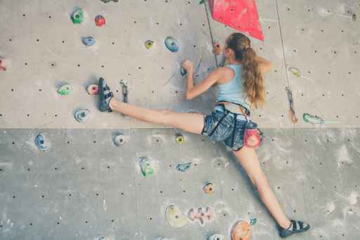 teenager climbing a rock wall