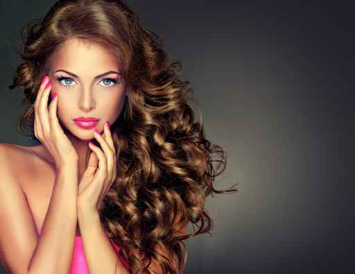Beautiful model brunette with long curled hair . Hairstyle wavy
