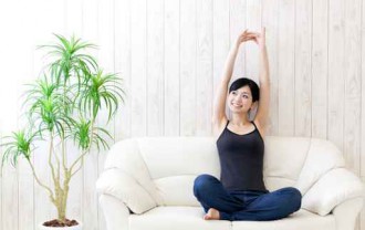a young asian woman stretching on the sofa