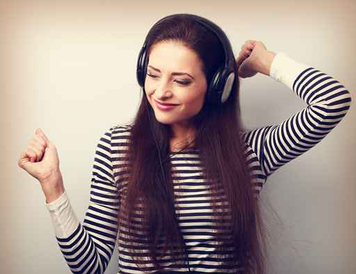 Young beautiful woman listening the music from headphones with d