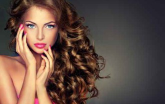 Beautiful model brunette with long curled hair . Hairstyle wavy